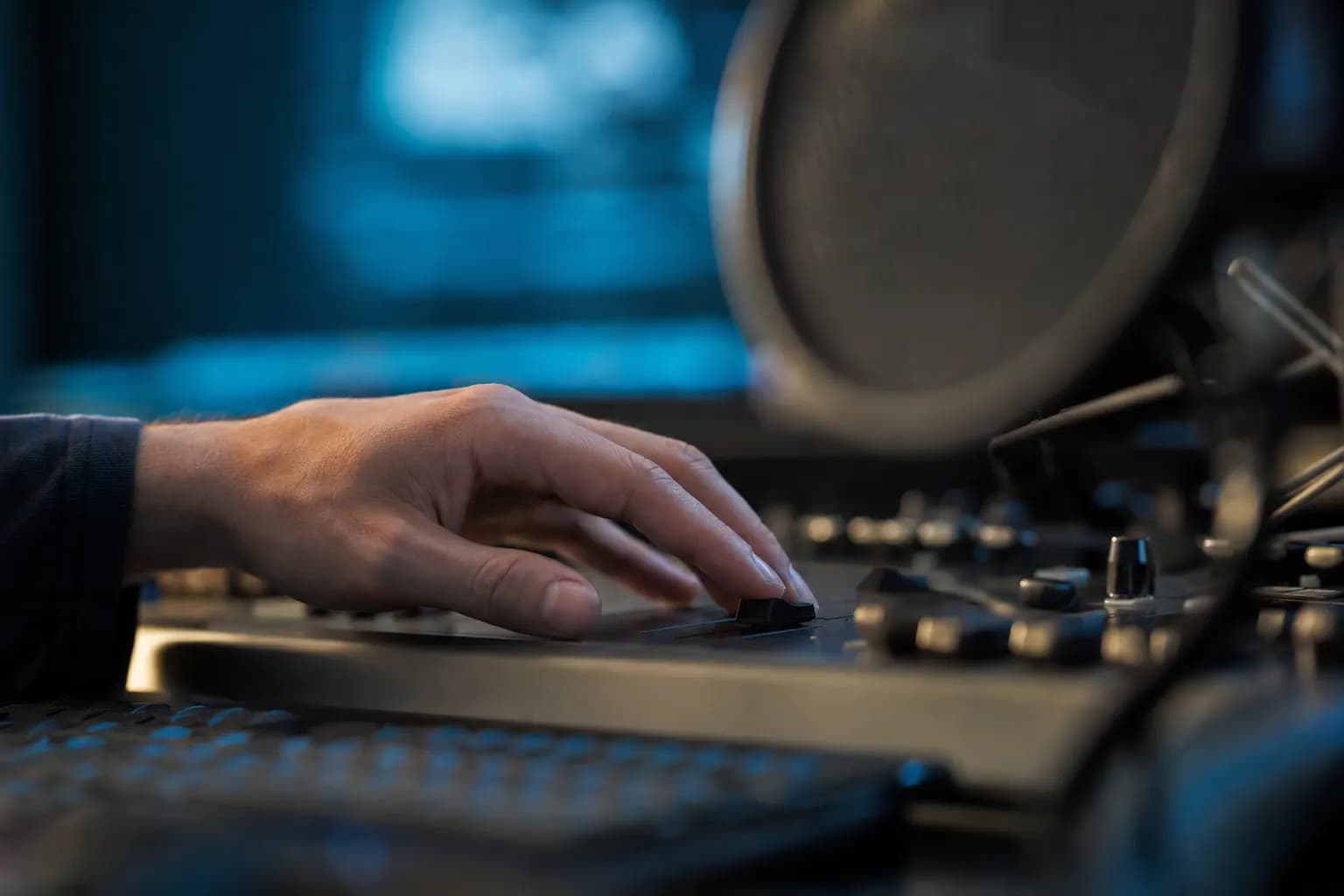 Hände justieren am Audio-Interface im Studio einen Regler.