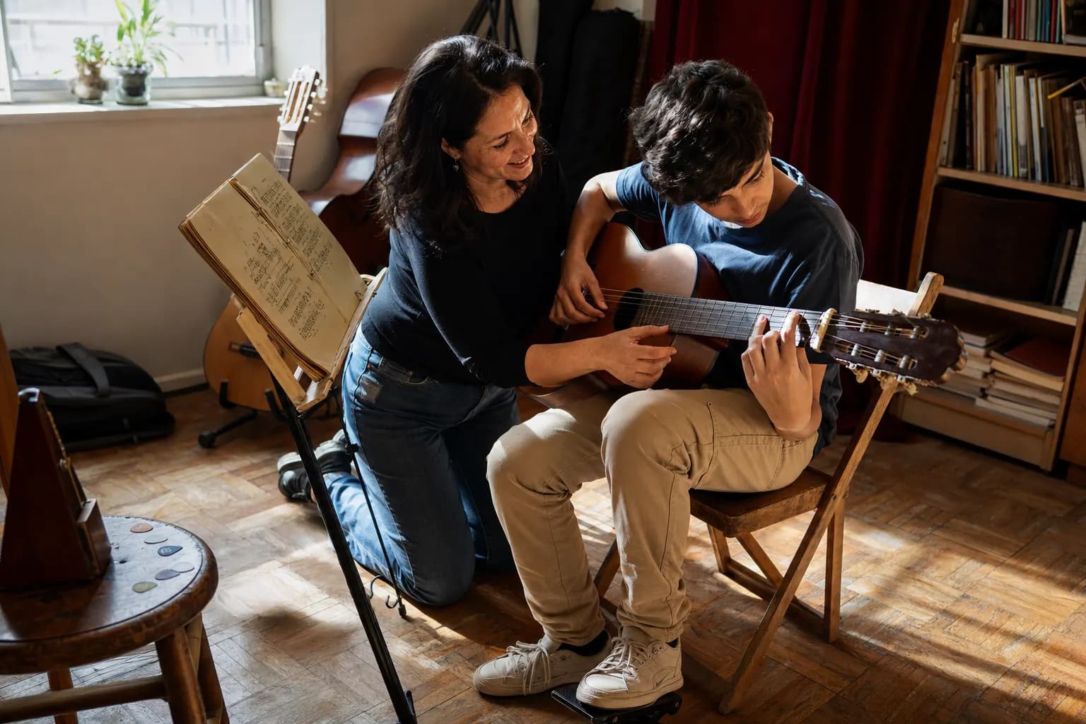 Musiklehrperson und Schüler gemeinsam beim Unterricht.